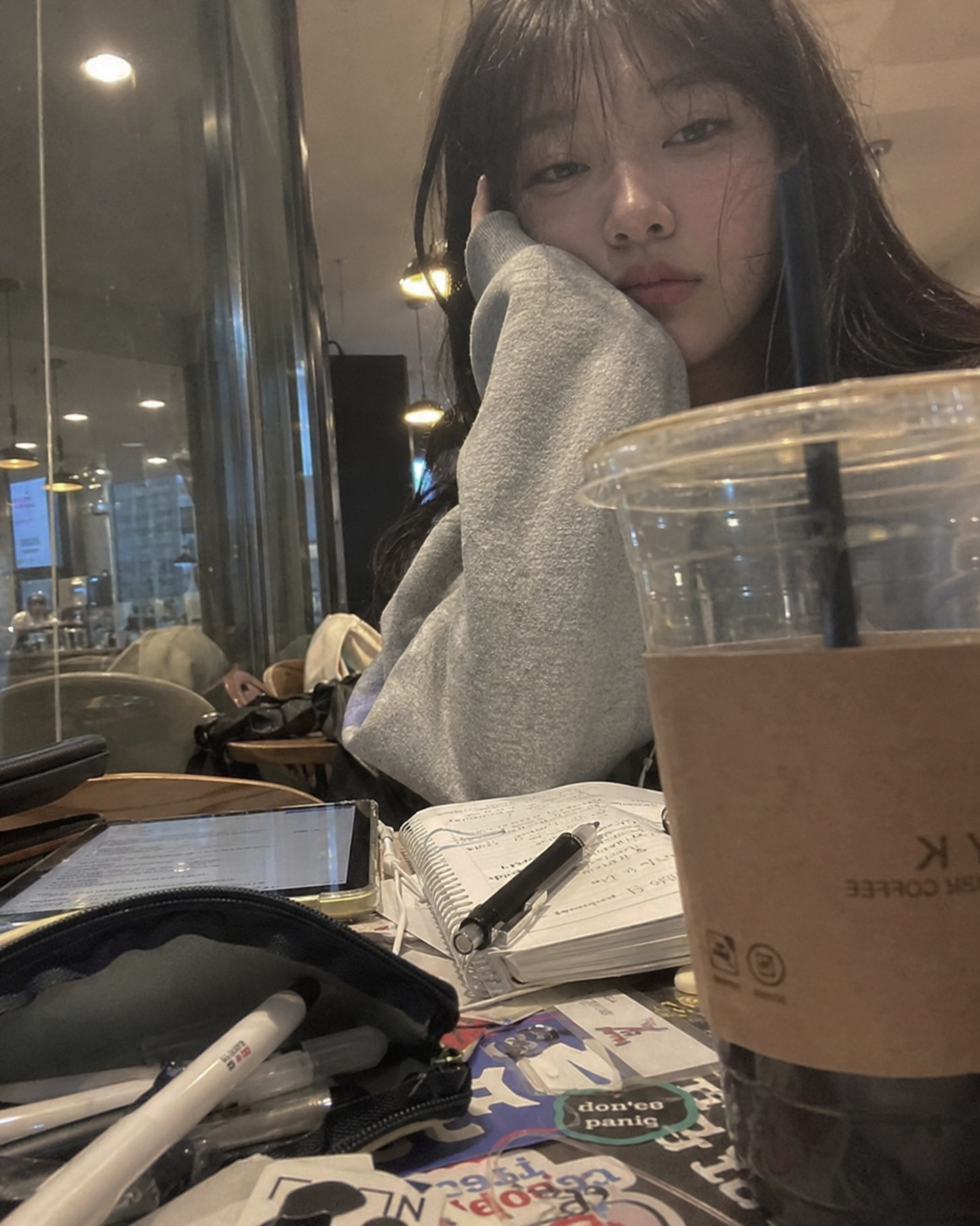 카페 테이블 너머로 촬영한 공부 중인 인물